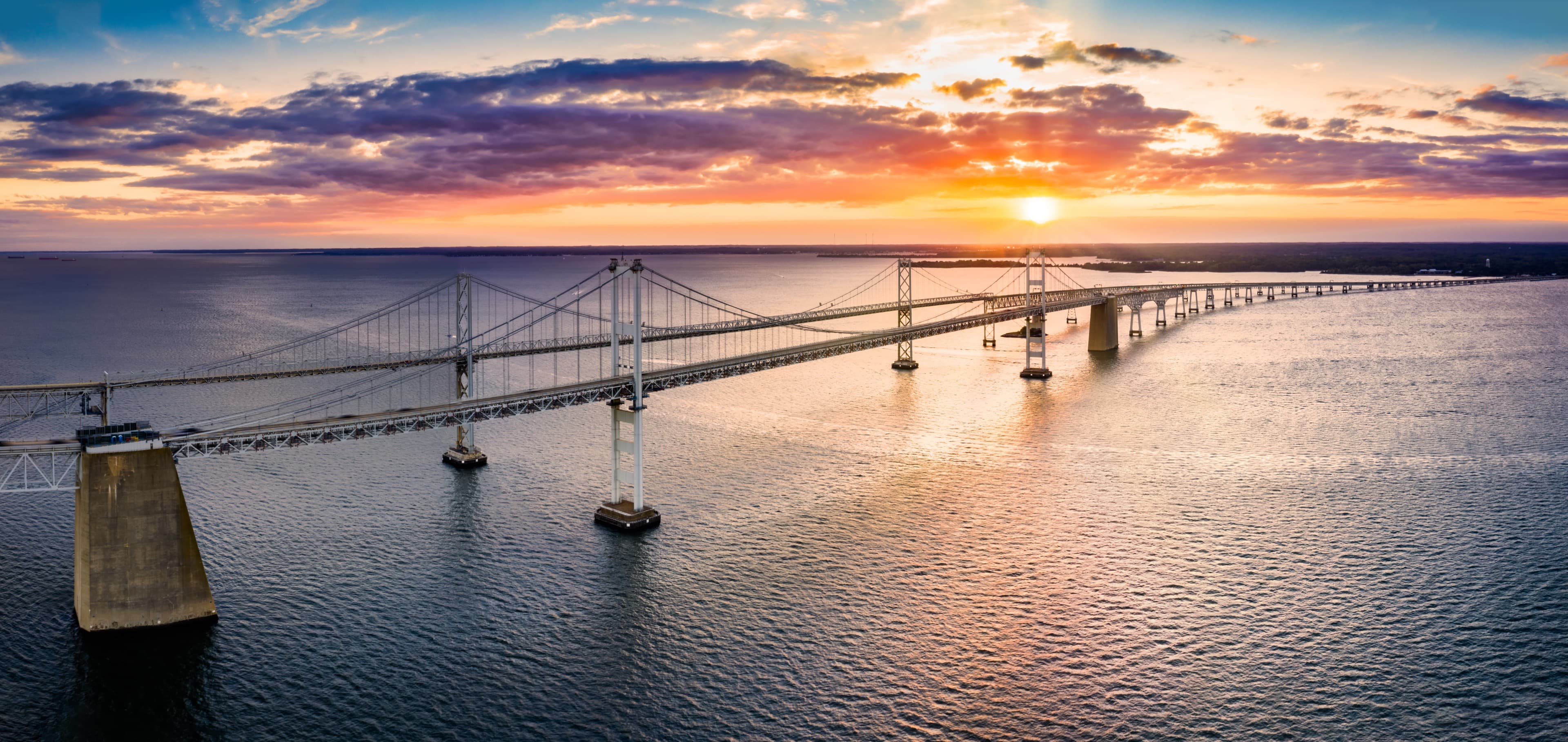 The Chesapeake Bay Bridge at sunset, stretching across the water